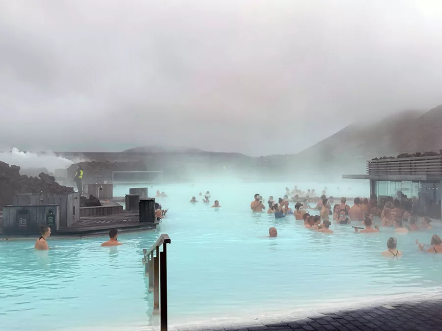 Visitors relaxing in the Blue Lagoon&rsquo;s milky blue geothermal water in Iceland.