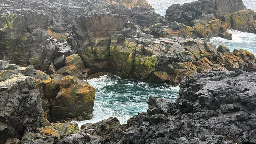 Crashing waves and dark lava crags near Brimketill lava rock pool