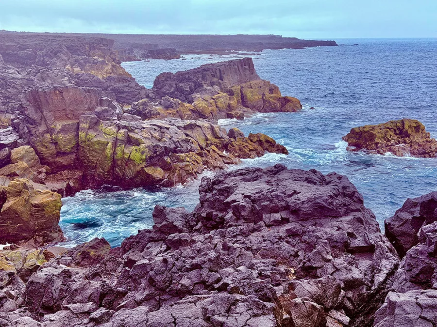 Black lava rocks and crashing ocean water at Brimketill on the Reykjanes Peninsula.