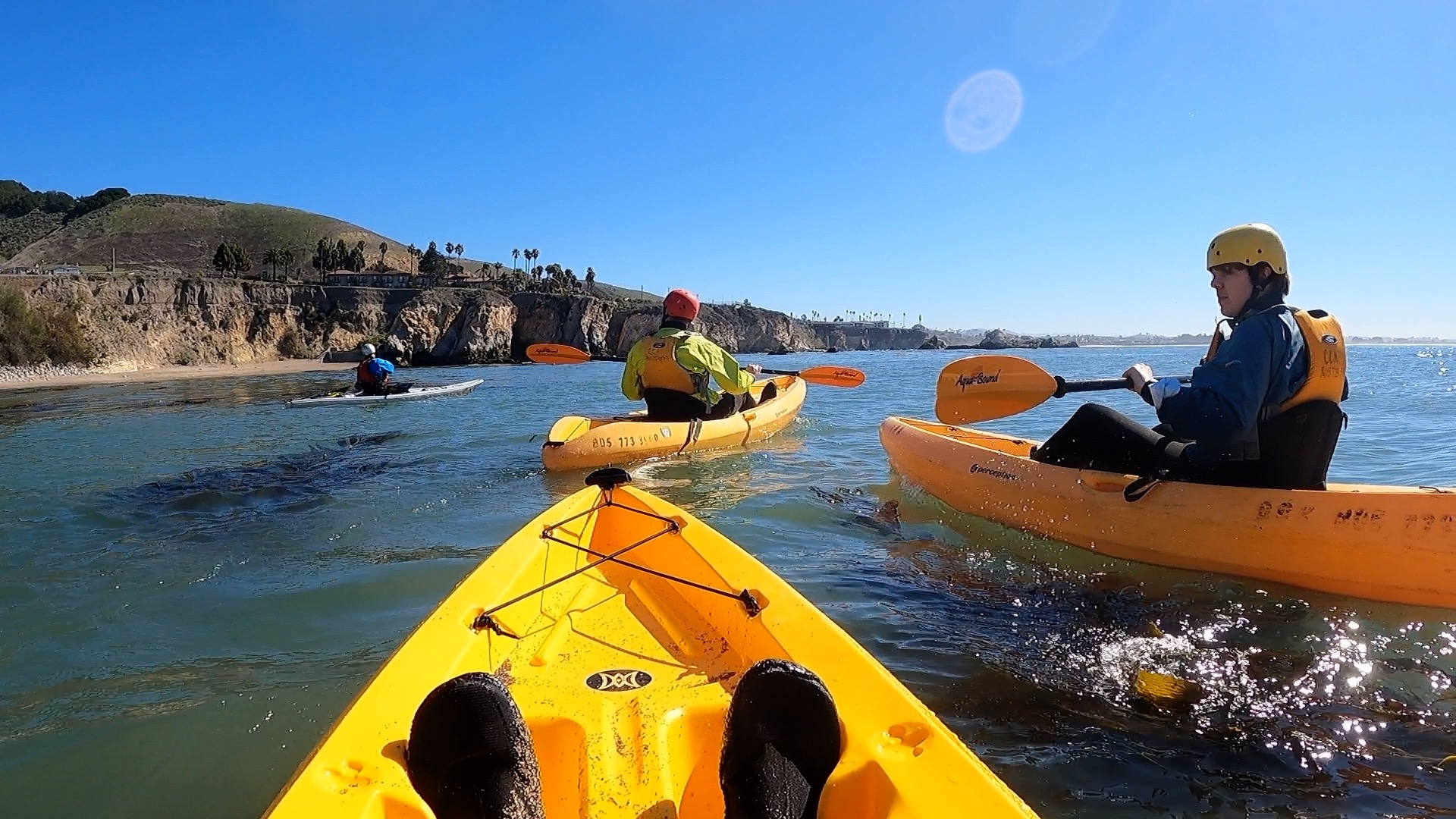Three kayakers being guided through open water