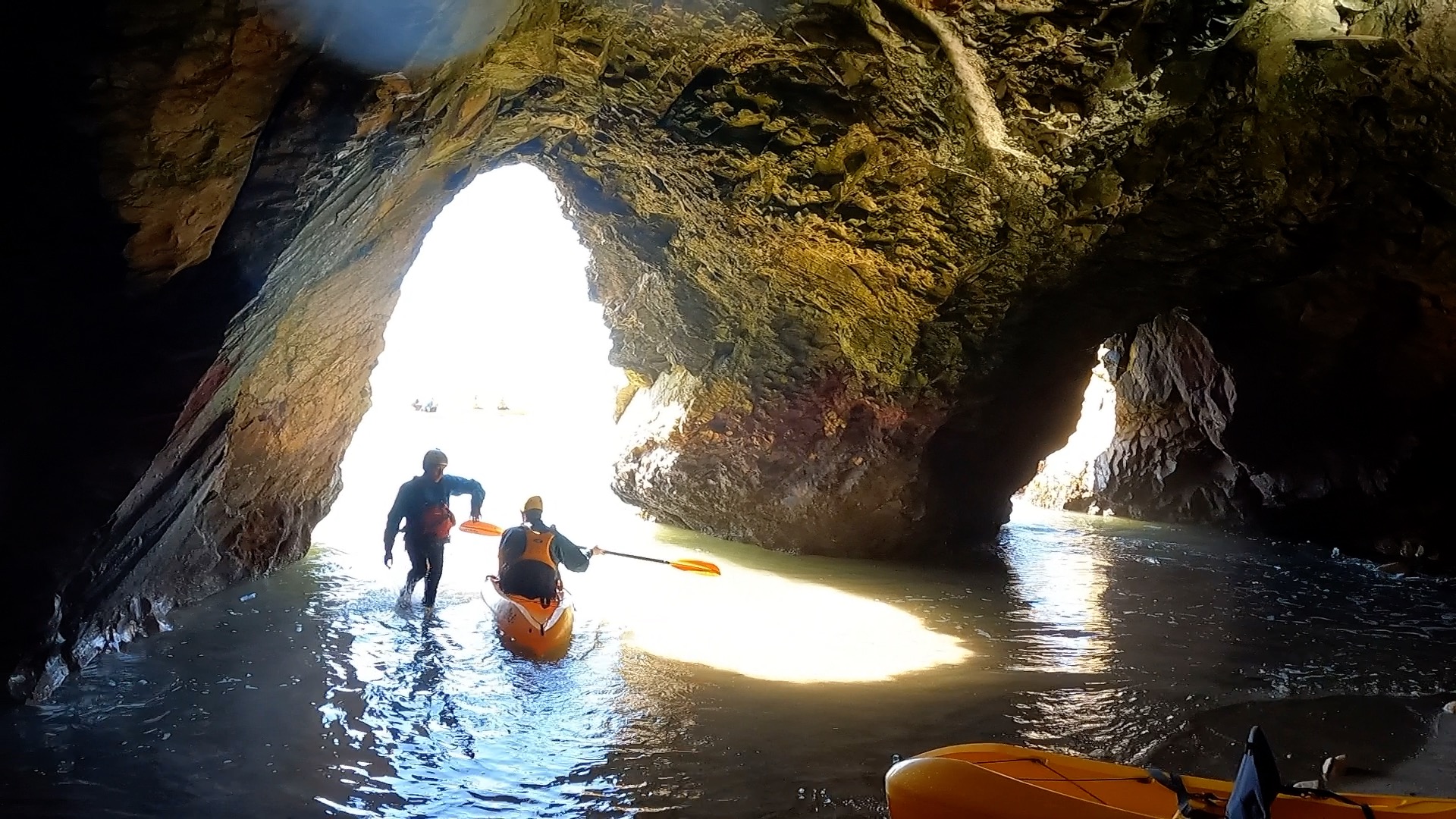 A kayak prepares to launch from a sea cave.
