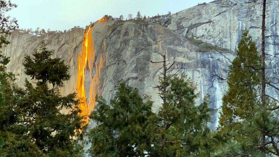 Bright orange Yosemite Firefall flowing down El Capitan in winter