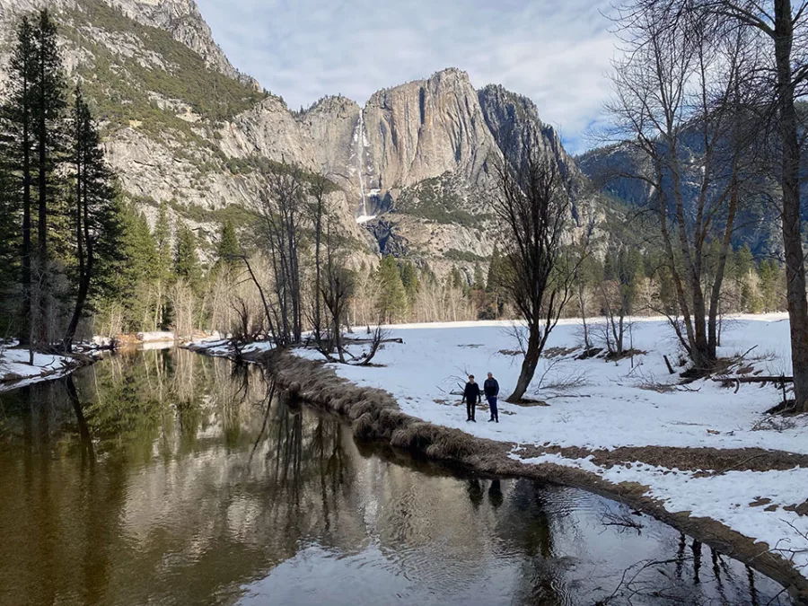 Snowy Merced River scene in Yosemite Valley with waterfall and granite cliffs